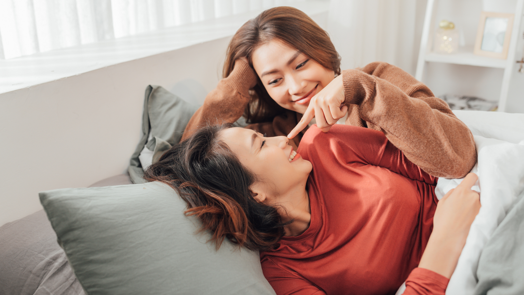 Una felice coppia femminile, scherza sul divano di casa